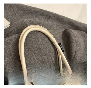 Détail du sac cabas en denim bleu clair avec anses en cuir crème et étiquette interne