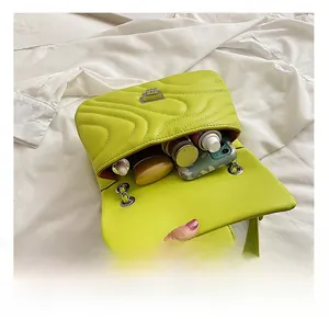 Internal view of neon green quilted chain bag showing capacity for phone and makeup