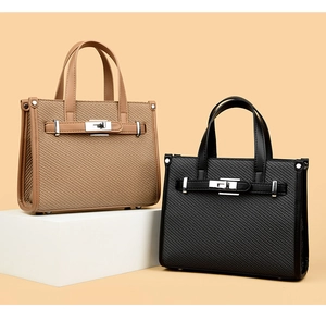 Detail of woven texture handbags in khaki and black with silver metal twist lock closures