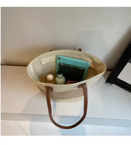 Top view of striped straw tote bag showing large interior space and leather handles