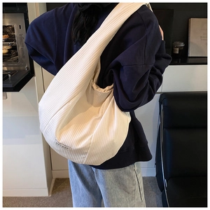 Dettaglio della borsa hobo in velluto a coste beige con trama rigata e piccola etichetta