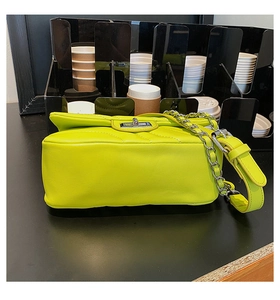 Detail of lime green quilted handbag featuring a silver twist lock and chain strap