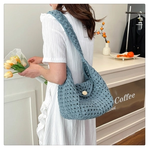 Detail of light blue hand-woven crochet shoulder bag with a rustic wooden button closure