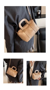 Detailed view of beige faux leather handbag with stitched stripes and gold hardware accents