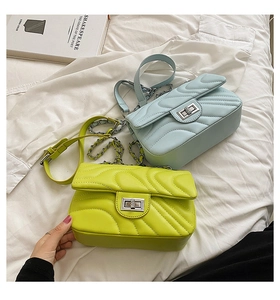 Detailed close-up of quilted chain bags in yellow and blue with silver rotating locks