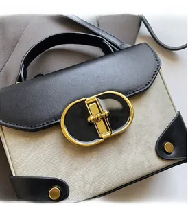Detailed macro view of the vintage black leather and grey canvas bag with gold oval lock