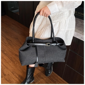 Détail d'un grand cabas en denim noir avec lanières en cuir pour un style quotidien