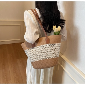 Detailed view of striped straw tote bag with brown leather straps and woven mesh design