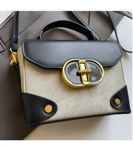 Detail of vintage small square bag with beige canvas, black leather and gold oval lock