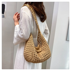 Detailed close-up of the intricate hand-woven hollow pattern on a khaki hobo bag
