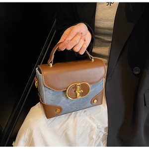 Detail of vintage box bag showing blue denim fabric and brown leather textures