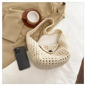 Macro detail of creamy white crochet shoulder bag with hollow-out pattern and wood button
