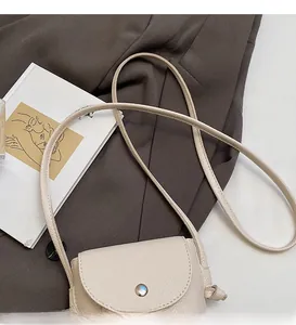 Detail of creamy white litchi textured faux leather phone bag with round metal buckle