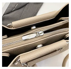Detail view of smooth silver zipper and interior magnetic buckle on lychee leather handbag