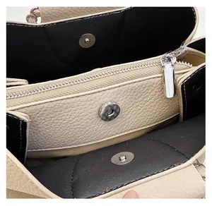 Detail view of lychee leather handbag interior with zipper divider and magnetic buckle