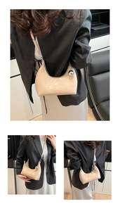 Détail du sac demi-lune beige avec gaufrage CLEARON et pendentif boule en métal argenté