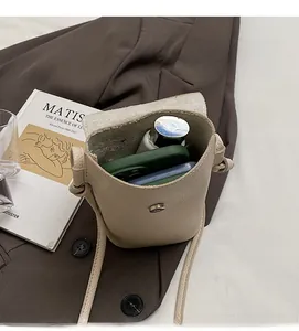 Interior view of beige leather bucket bag showing space for a phone and makeup