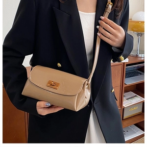 Détail d'un sac à bandoulière vintage en cuir beige avec fermoir doré rotatif