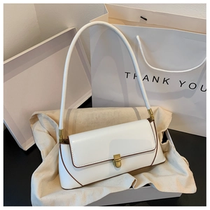 Detail of white minimalist baguette bag with brown edges and golden metal buckle