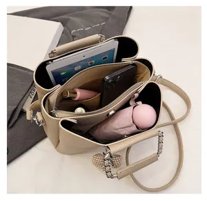 Interior view of beige leather handbag with multiple compartments for tablet and essentials