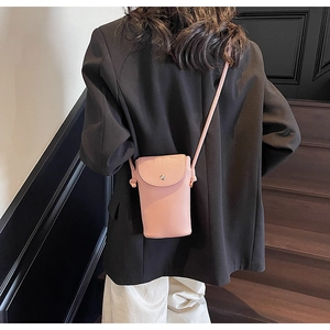 Pink lychee grain faux leather crossbody phone bag shown on shoulder over a black blazer