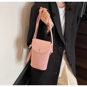 Detail of pink lychee leather crossbody phone bag showing flap button and knot design