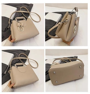 Detail view of beige lychee texture bag with pearl bow charm and bottom metal studs