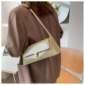 Detailed view of the square metallic buckle on a minimalist baguette shoulder bag
