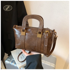 Detail of vintage brown leather Boston bag with metal hardware and top handles