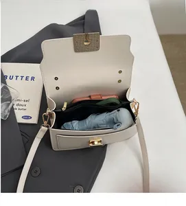 Detail view of cream crossbody bag interior showing large capacity for umbrella and phone