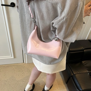 Détail du sac hobo en cuir rose avec gaufrage CLEA CK et grand détail de boule en métal argenté