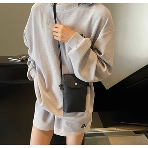 Close-up of black litchi texture crossbody bag with silver magnetic snap buckle