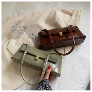 Detail of vintage baguette shoulder bags in brown and green with golden metal buckles