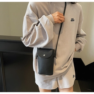 Close-up of black litchi pattern phone crossbody bag with silver magnetic snap buckle