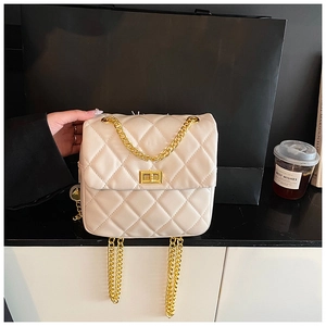 Détail du sac à bandoulière matelassé crème avec chaîne dorée et fermoir pivotant en métal