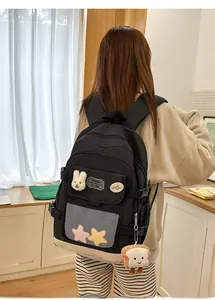 Detail of large capacity black backpack with plush toast charm and mesh pocket on back