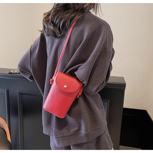 Close-up of red lychee textured crossbody phone bag featuring a silver metal snap button