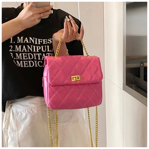 Gros plan du sac bandoulière matelassé rose avec chaîne dorée et fermoir rotatif
