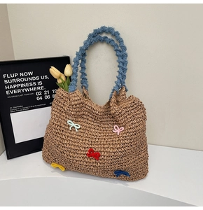 Detailed texture of straw woven tote bag featuring colorful bows and blue handles