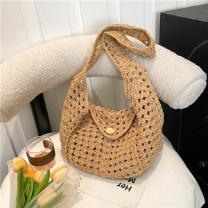 Handcrafted woven beige crochet shoulder bag with a vintage wooden button on a chair