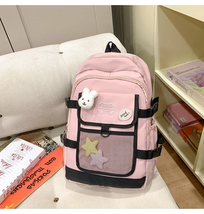 Pink school backpack with white bunny plush charm and star badges on mesh pocket detail