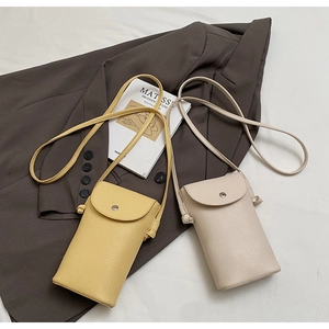 Detail of lychee textured faux leather mini bags with magnetic snap closure on lifestyle background