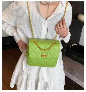 Détail d'un sac à bandoulière matelassé vert vif avec chaîne dorée et fermoir à tourniquet