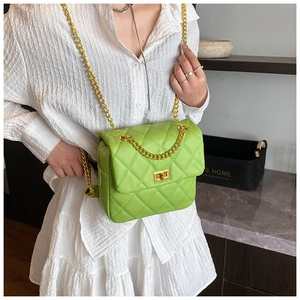 Détail macro du sac en cuir matelassé vert herbe avec bandoulière chaîne dorée et fermoir
