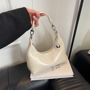 Sac demi-lune beige chic, finition brillante avec pendentif boule argentée