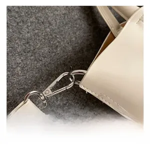 Close-up of white leather handbag silver metal lobster clasp and premium stitching detail