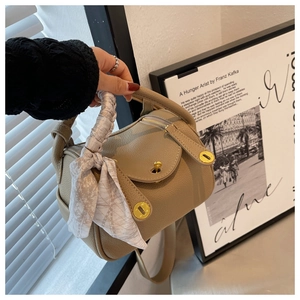 Detailopname van de kaki lederen Lindy handtas met zijden sjaal en gouden hardware