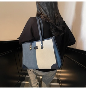 Vista posteriore di una modella con borsa in denim blu e tela crema con finiture