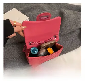 Internal capacity of pink quilted leather chain bag showing phone and cosmetics