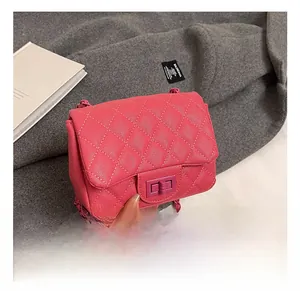 Detail of rose pink quilted chain bag with matching rectangular twist lock and texture